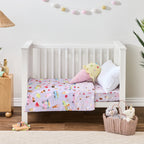 bb&b Kids Ice Cream Shop cot styled with a lilac cot cover featuring colourful ice creams, popsicles, cherries and ice cream trucks, with an ice cream-shaped cushion and white pillow.