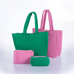 Matching woven tote bags and cosmetic pouches in green and pink displayed together on a white background.
