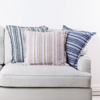 Home Co. Riley striped cushions in Olive, Natural and Navy styled together on a neutral sofa.