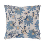 A square cushion featuring textured blue floral embroidery on a soft natural background is displayed against a clean white backdrop, showcasing its elegant botanical design.