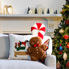Christmas cushions, including a red and green check Christmas tree cushion, arranged on a white sofa beside a decorated Christmas tree.