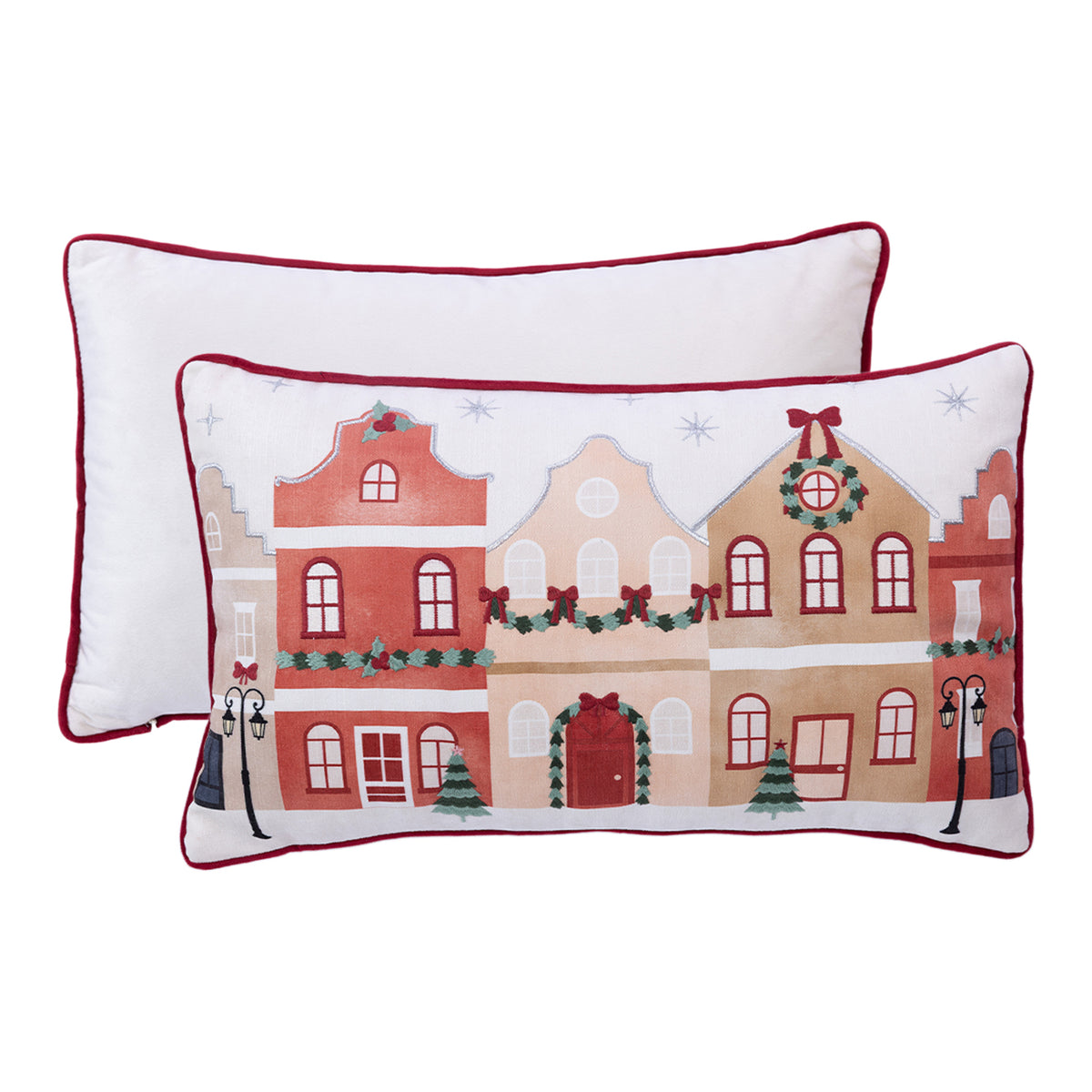 Front and back views of the Christmas Town Cushion featuring colourful festive buildings, Christmas garlands and red piping against a white background.