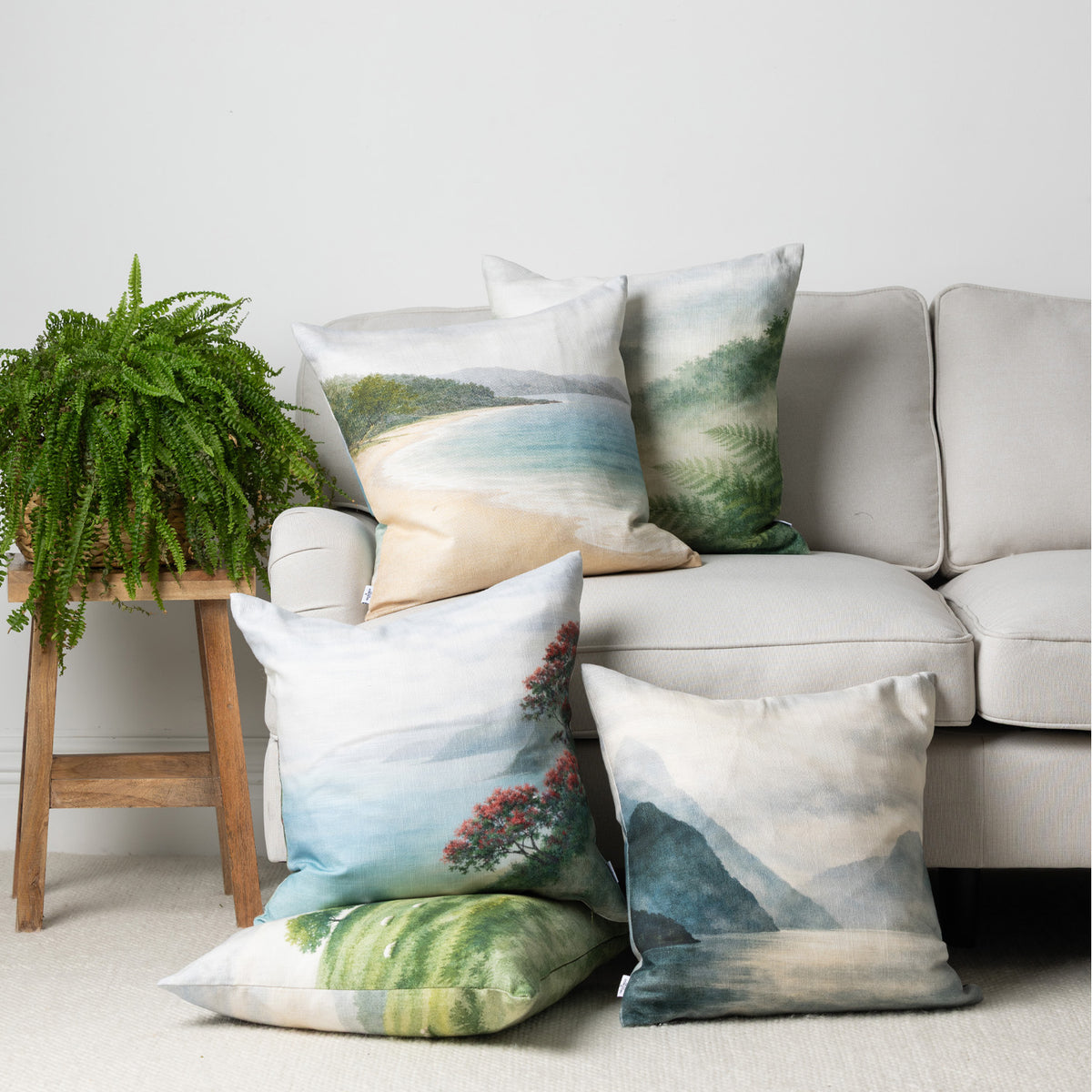 Fieldcrest coastal cushion collection styled around a neutral sofa with scenic New Zealand-inspired landscape designs in soft blue, green and natural tones.