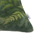 Close-up of the Fieldcrest Northland Forest Cushion corner showing the textured fabric, deep green foliage print and Fieldcrest brand label.