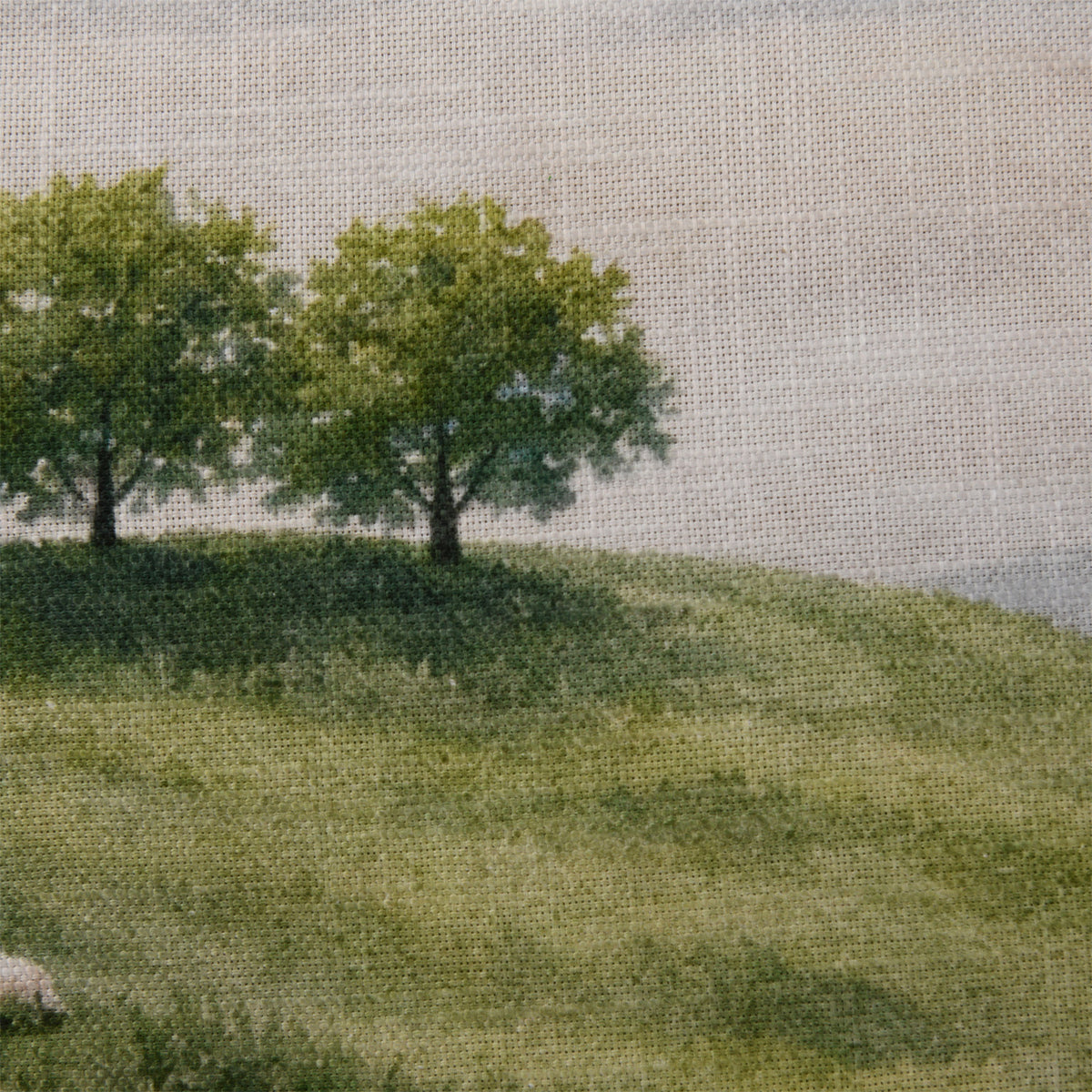 Close-up of the Fieldcrest Whanganui Grazing Cushion showing the woven fabric texture, rolling green hills and tree details.