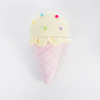 A plush ice cream cone cushion with a pale yellow scoop topped with small colorful pom-pom sprinkles and a pink waffle-cone body, photographed on a clean white background.
