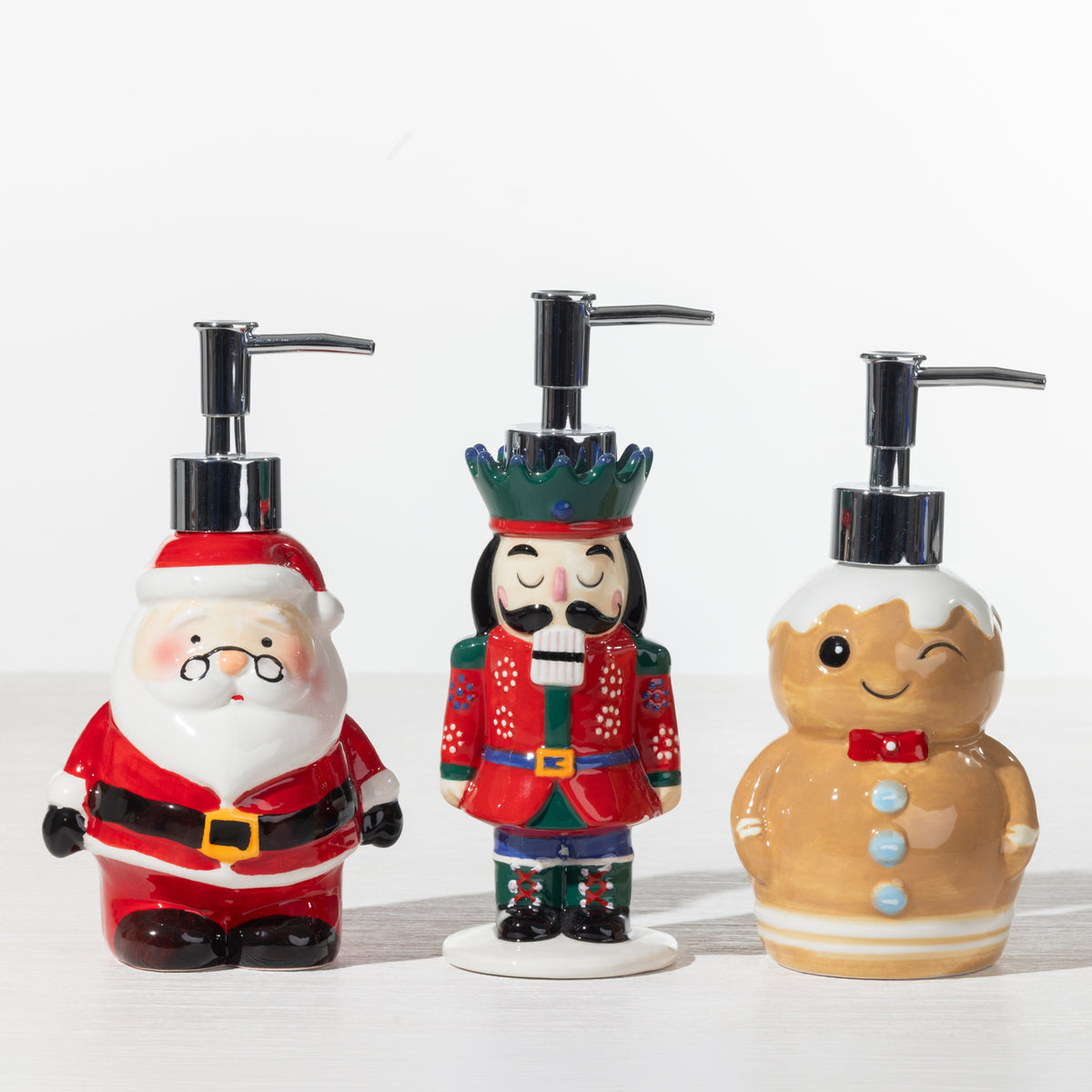 Christmas Wishes Santa, Nutcracker and Gingerbread festive soap dispensers displayed together on a white background.