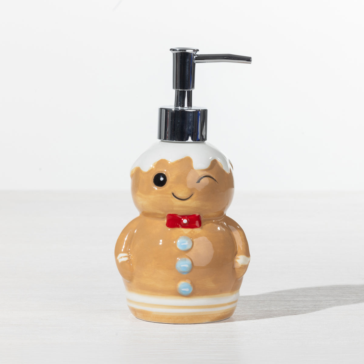 Christmas Wishes Gingerbread soap dispenser with white icing detail, red bow tie, blue buttons and silver pump.