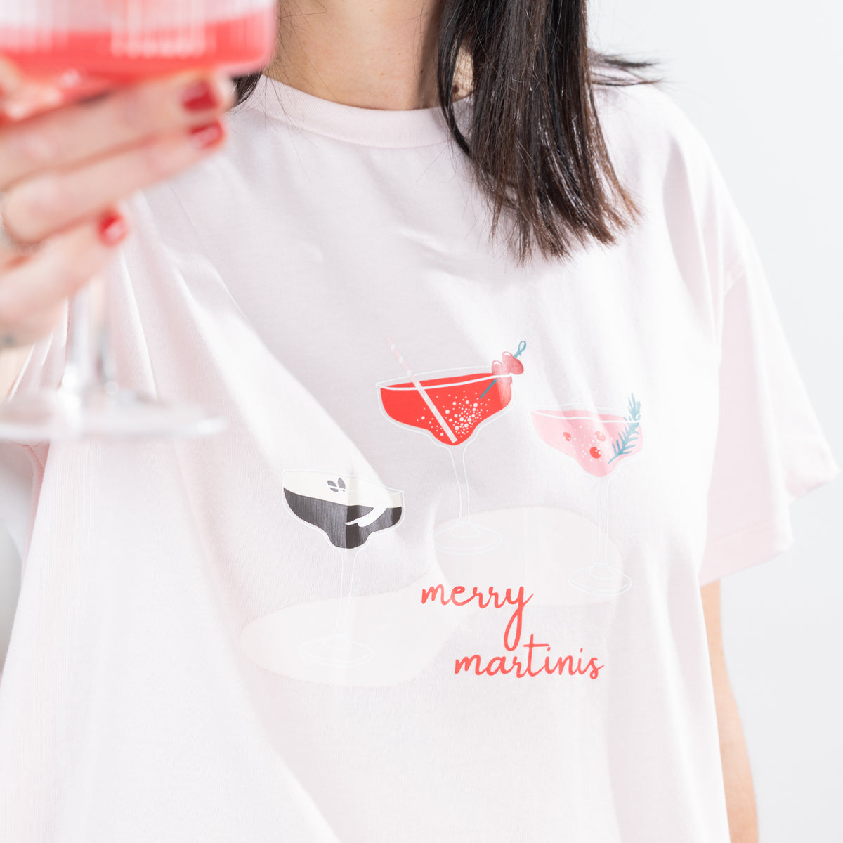 Close-up of the Christmas Wishes Merry Martinis Tee in pink showing the colourful cocktail glass artwork and Merry Martinis slogan.