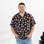 Man wearing the black Christmas Wishes unisex festive shirt with a pōhutukawa flower and jandal print.