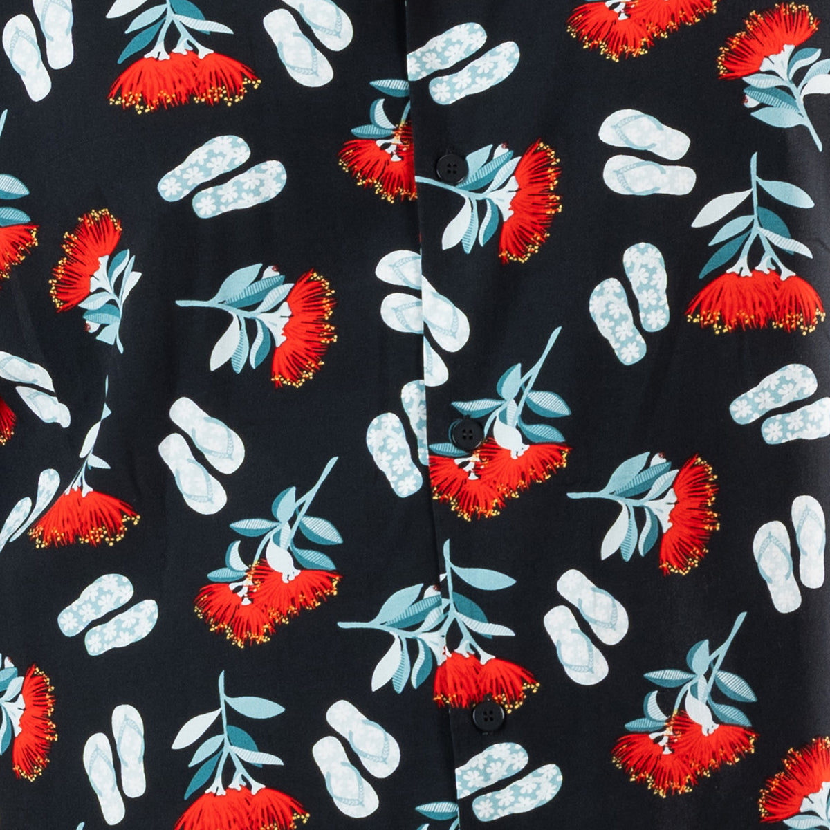 Close-up of the black festive shirt print featuring red pōhutukawa flowers and light blue jandals.