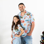 Man and girl wearing matching faded blue Christmas Wishes Cheeky Santa festive shirts.