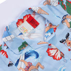 Close-up of the faded blue Christmas Wishes kids festive shirt collar and label, showing the colourful summer Christmas print.