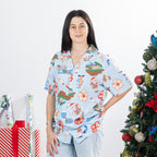 Woman wearing the faded blue Christmas Wishes unisex Cheeky Santa festive shirt beside a decorated Christmas tree.