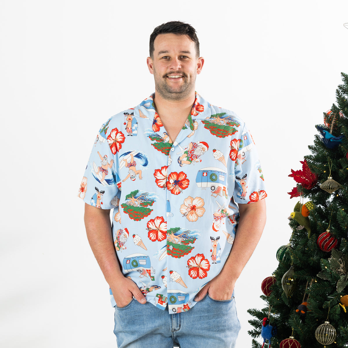 Man wearing the faded blue Christmas Wishes unisex Cheeky Santa festive shirt with blue jeans.