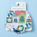 White Christmas Wishes dog bandana displayed on branded packaging, featuring Christmas trees, ornaments, gifts, wreaths, jandals and tui birds.