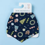 Navy Christmas Wishes dog bandana displayed on branded packaging, featuring festive wreaths, Christmas trees, gingerbread houses, crackers and ornaments.