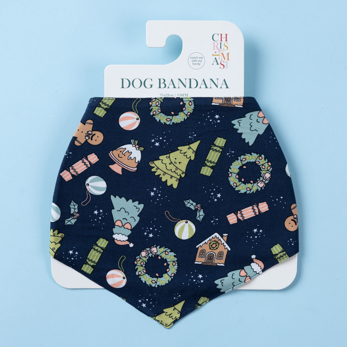 Navy Christmas Wishes dog bandana displayed on branded packaging, featuring festive wreaths, Christmas trees, gingerbread houses, crackers and ornaments.