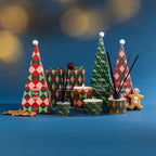 A festive fragrance collection featuring colourful Christmas candles and diffusers in playful geometric packaging, styled with seasonal accents against a rich blue backdrop.