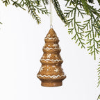 Gingerbread-style ceramic Christmas tree hanging decoration with white snowflake and zigzag detailing, displayed hanging from a Christmas tree branch.