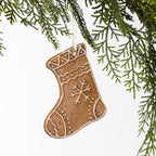 Gingerbread-style ceramic Christmas stocking hanging decoration with white snowflake and icing-inspired detailing, suspended from a cream ribbon.