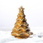 Gingerbread-style ceramic LED Christmas tree with white icing details, star cut-outs and a star topper, displayed in a snowy setting.