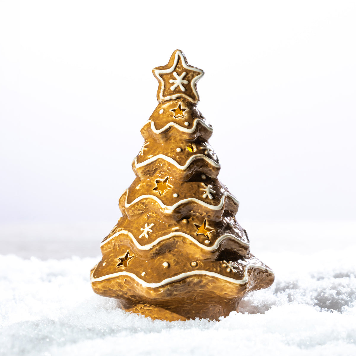 Gingerbread-style ceramic LED Christmas tree with white icing details, star cut-outs and a star topper, displayed in a snowy setting.