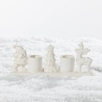 White ceramic two-candle holder featuring festive Santa, Christmas tree and reindeer figures on a snowy background.