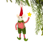 A felt Christmas mouse ornament hanging from a green pine branch. The mouse wears a red and white striped shirt, green shorts, a red pointed hat, and holds a yellow star against a white background.