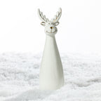 Large white ceramic Christmas reindeer decoration featuring tall gold-accented antlers, a smiling face and a sleek tapered body, displayed on a snowy surface.