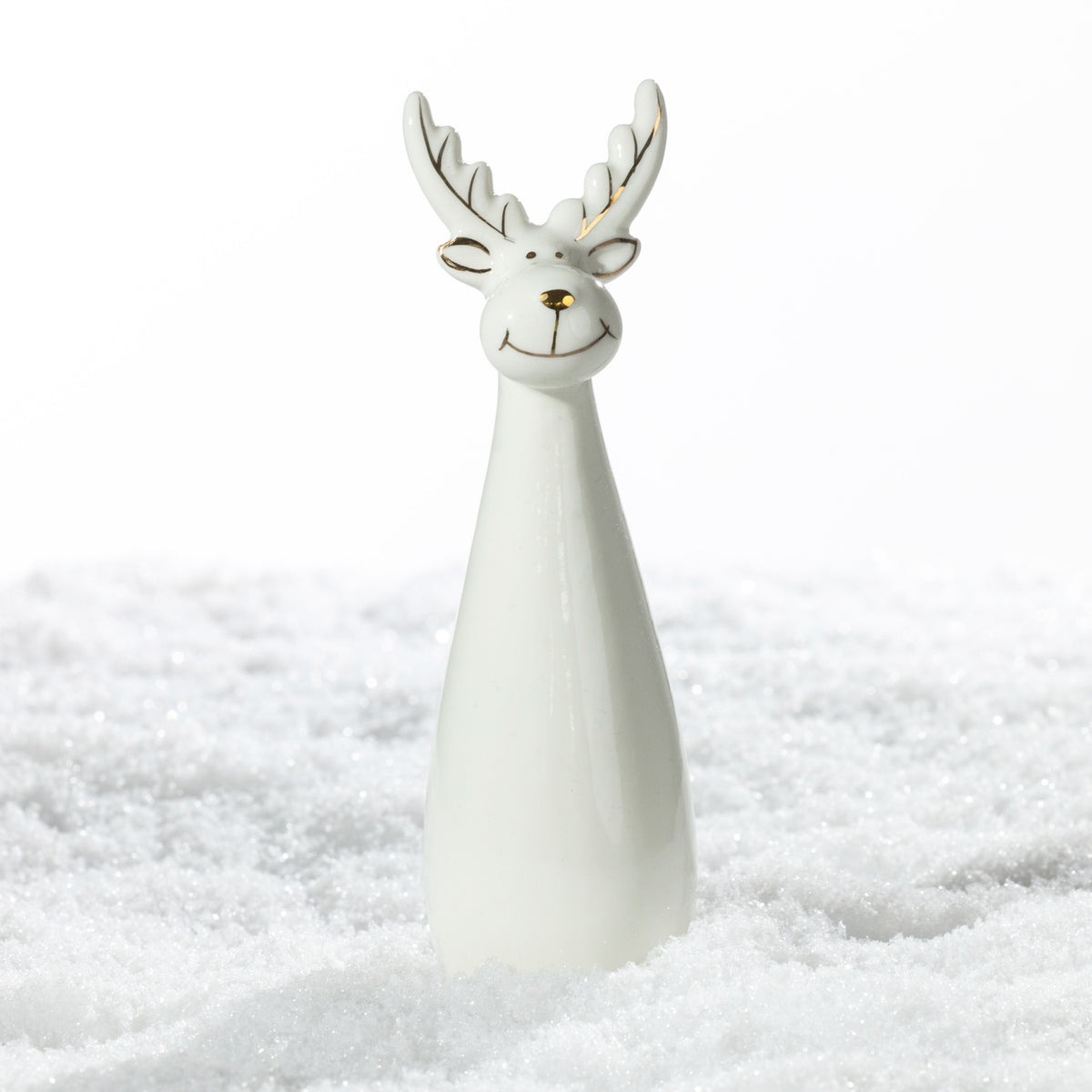 Large white ceramic Christmas reindeer decoration featuring tall gold-accented antlers, a smiling face and a sleek tapered body, displayed on a snowy surface.