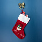Antique gold bow wall hook holding a red Christmas stocking with a snowman design and white fluffy cuff against a blue background.