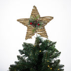 Christmas Wishes natural rattan star tree topper decorated with festive greenery, pinecones and red berries, displayed on top of a Christmas tree.
