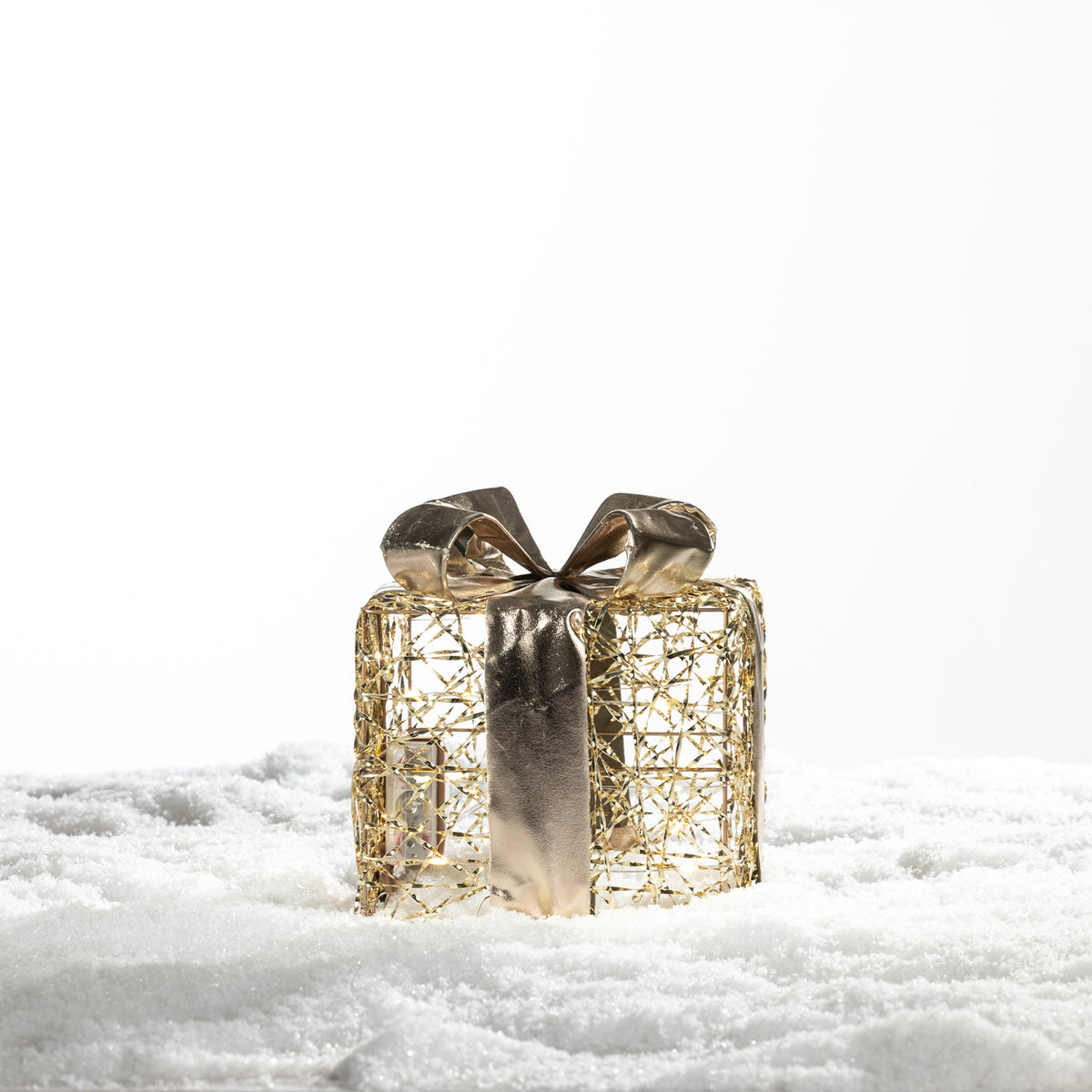 Small Christmas Wishes gold present box LED decoration with an open wire design, metallic gold ribbon and bow on a snowy background.