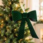 Christmas Wishes green velvet present bow with sparkling dot details, displayed on a lit Christmas tree.