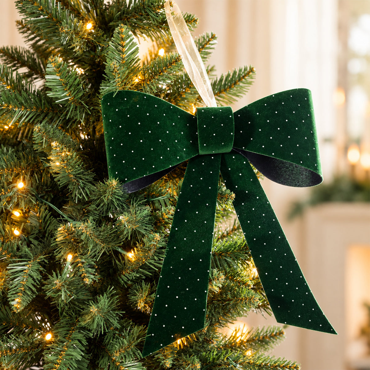 Christmas Wishes green velvet present bow with sparkling dot details, displayed on a lit Christmas tree.