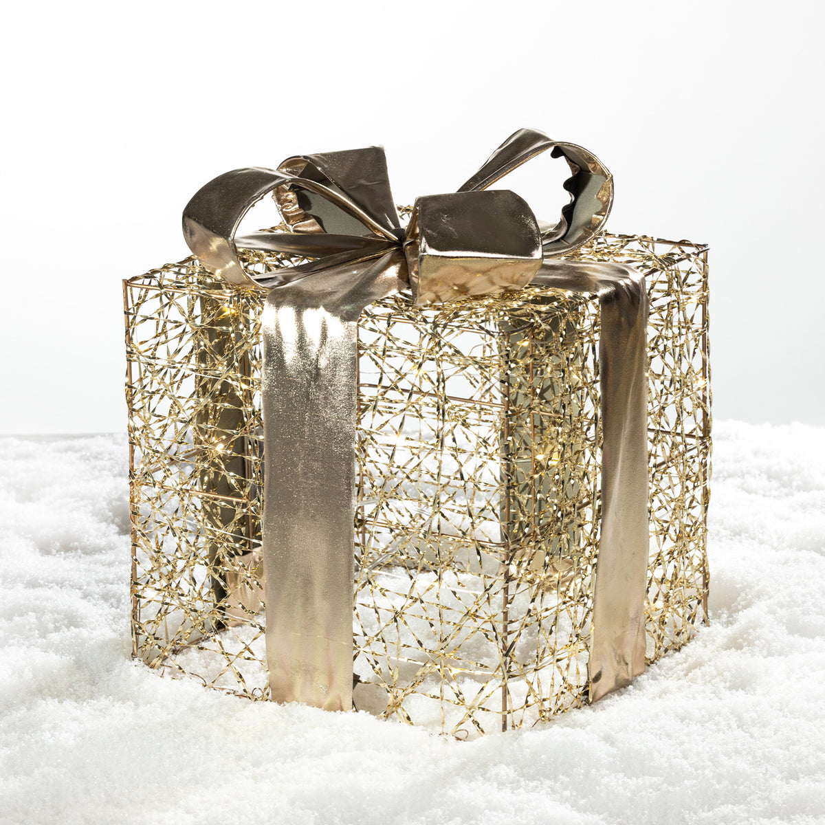 Christmas Wishes gold present box LED decoration with an open wire design, metallic ribbon and bow, displayed on a snowy background.