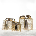 Set of three Christmas Wishes gold present box LED decorations with metallic bows, displayed together on a snowy background.