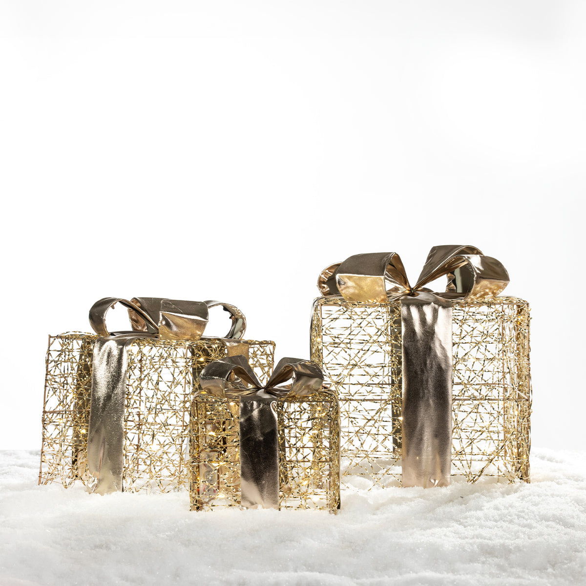 Set of three Christmas Wishes gold present box LED decorations with metallic bows, displayed together on a snowy background.