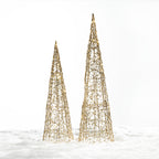 Christmas Wishes gold cone tree LED decorations in two sizes with an open woven design and warm white lights, displayed in a snowy setting.