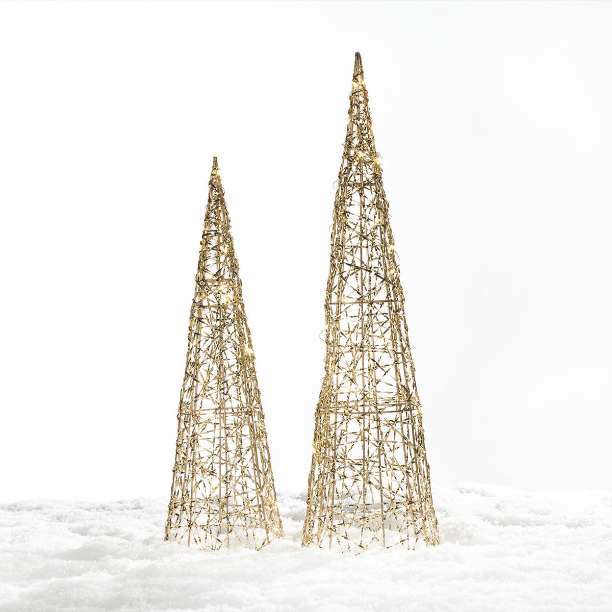 Christmas Wishes gold cone tree LED decorations in two sizes with an open woven design and warm white lights, displayed in a snowy setting.
