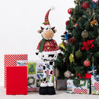A Christmas cow figurine standing around presents & a tree.