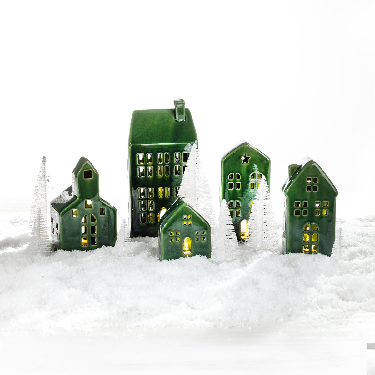 Create a magical festive display with the Christmas Wishes Ceramic Village 12 Piece Set, featuring green ceramic houses, warm lights and miniature trees.
