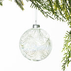 Christmas Wishes Clear White Lace Glass Bauble – Clear glass round bauble decorated with delicate white lace-inspired swirls and glitter detailing for an elegant, frosted Christmas look.