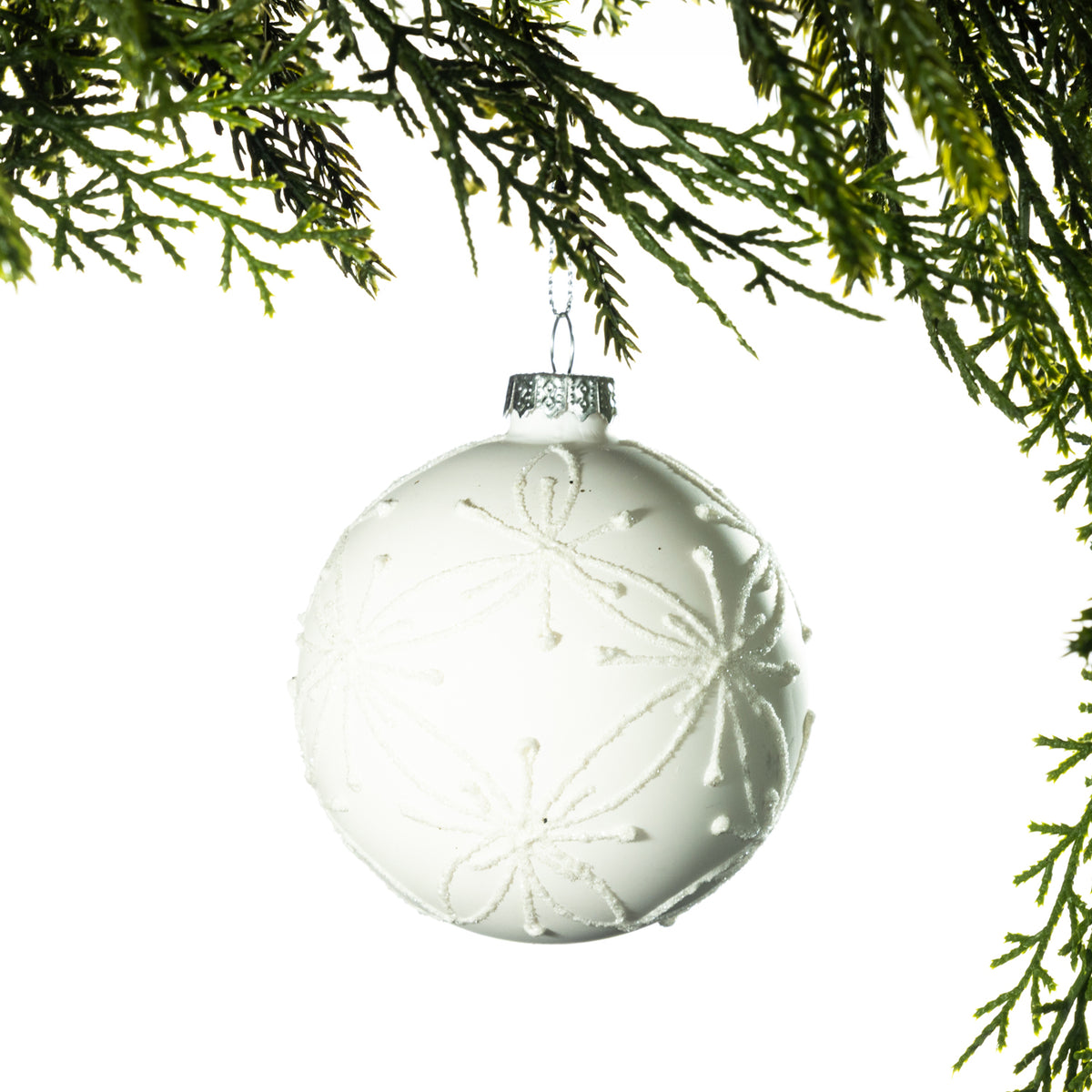 Christmas Wishes White Glitter Flower Bauble – White round Christmas bauble featuring delicate glitter flower motifs across the surface, creating a soft and elegant festive finish.
