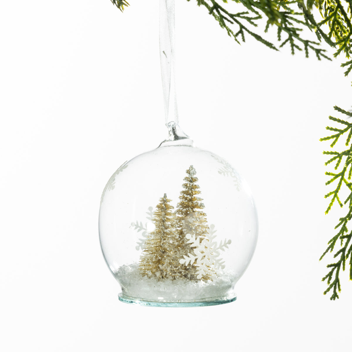 Christmas Wishes Gold Christmas Tree Snow Globe Bauble – Clear snow globe-style bauble featuring miniature gold-toned Christmas trees, snowflake accents and faux snow for an elegant winter-inspired look.