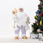Christmas Wishes White & Gold Santa 80cm dressed in a white and gold festive outfit, holding gold decorations and silver baubles beside a decorated Christmas tree.