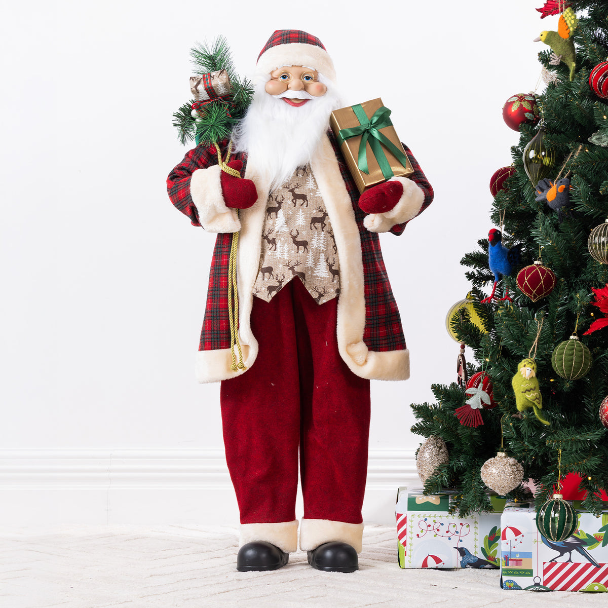 Christmas Wishes Red Traditional Santa 110cm dressed in a red tartan and cream-trimmed outfit, holding festive greenery and a gold gift with a green bow.