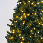 Warm white LED starburst Christmas tree lights glowing on a dark green artificial pine tree against a light gray background.