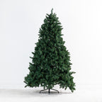 A pre-lit artificial Christmas tree with dense green needles on a black metal stand, set against a plain white studio background.
